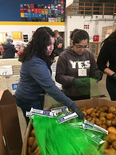 Volunteers, Tamara Valadez and Santa Herrera, bag fresh fruit at the Sacramento Food Bank. Spring 2017
