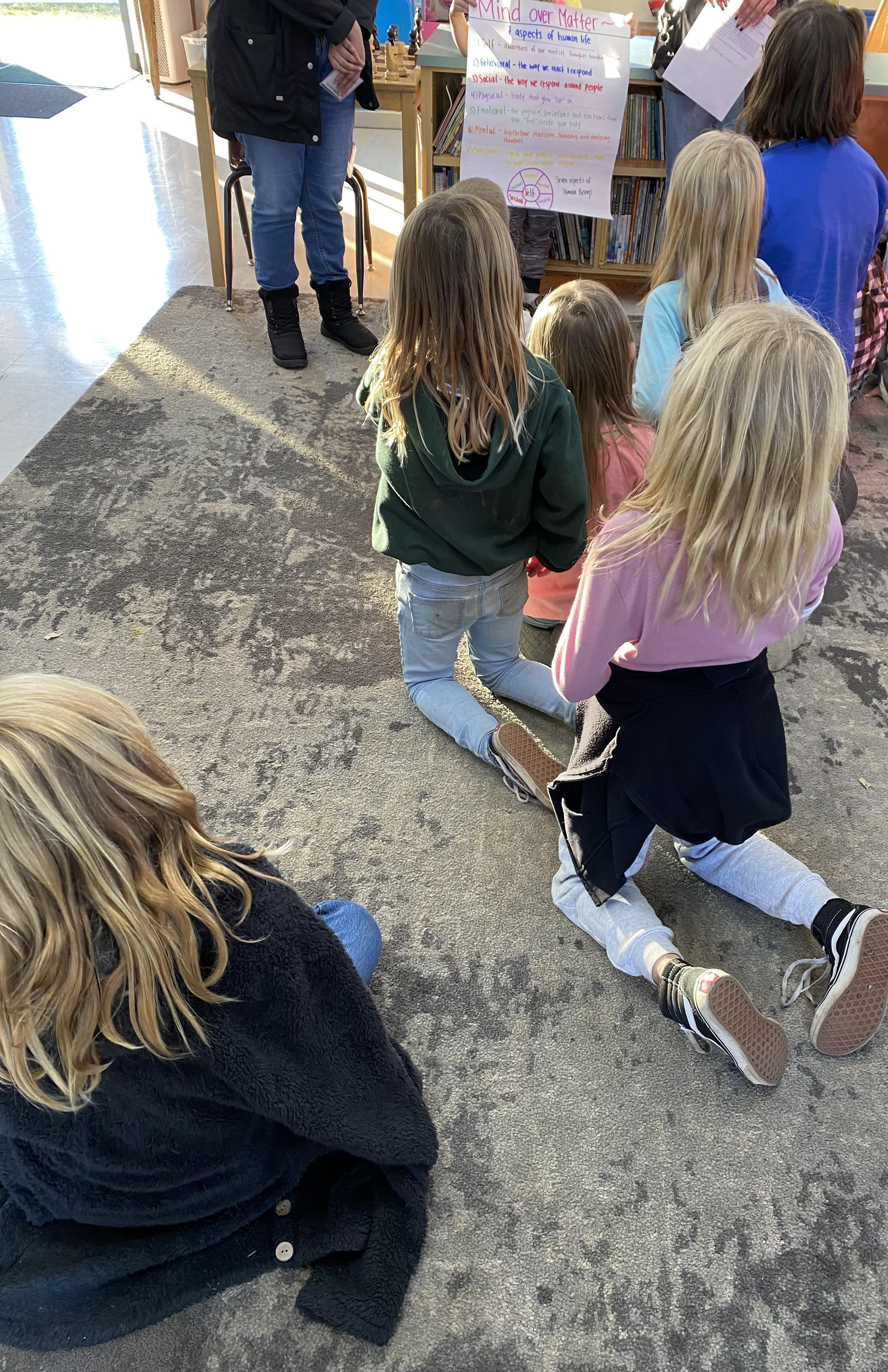 A small group of elementary school students gather during an after school activity hosted by YMP volunteers called "Mind Over Matter" which focused on age-appropriate emotions and wellness habits