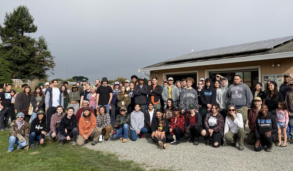 A large group of volunteers gather at the Potawot Community Food Garden