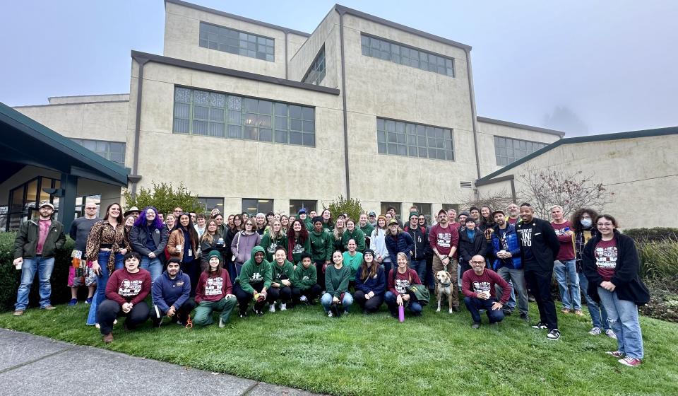 A large group of volunteers stand in front of the SBS building at Cal Poly Humboldt before leaving for sites on MLK Day