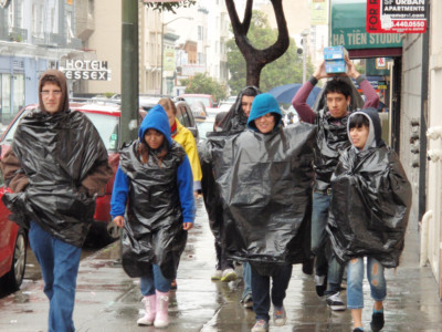 STEP UPP volunteers explore San Francisco surroundings wearing garbage bag raincoats.